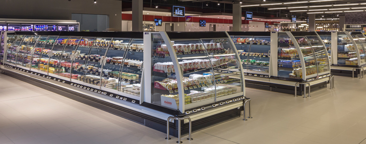 Reihe von gebogenenen ShapeFlex Curve Isolierglasschiebetüren für halbhohe Kühlregale im Supermarkt mit eleganter Produktdarbietung