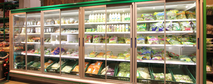 Wandkühlregal mit selbstschließenden Schiebetüren im Supermarkt mit frischen Artikeln befüllt
