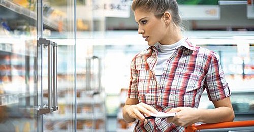 Frau vor Kühlregal mit REMIS-Isolierglasklapptür beim Einkauf in Ihrem Supermarkt